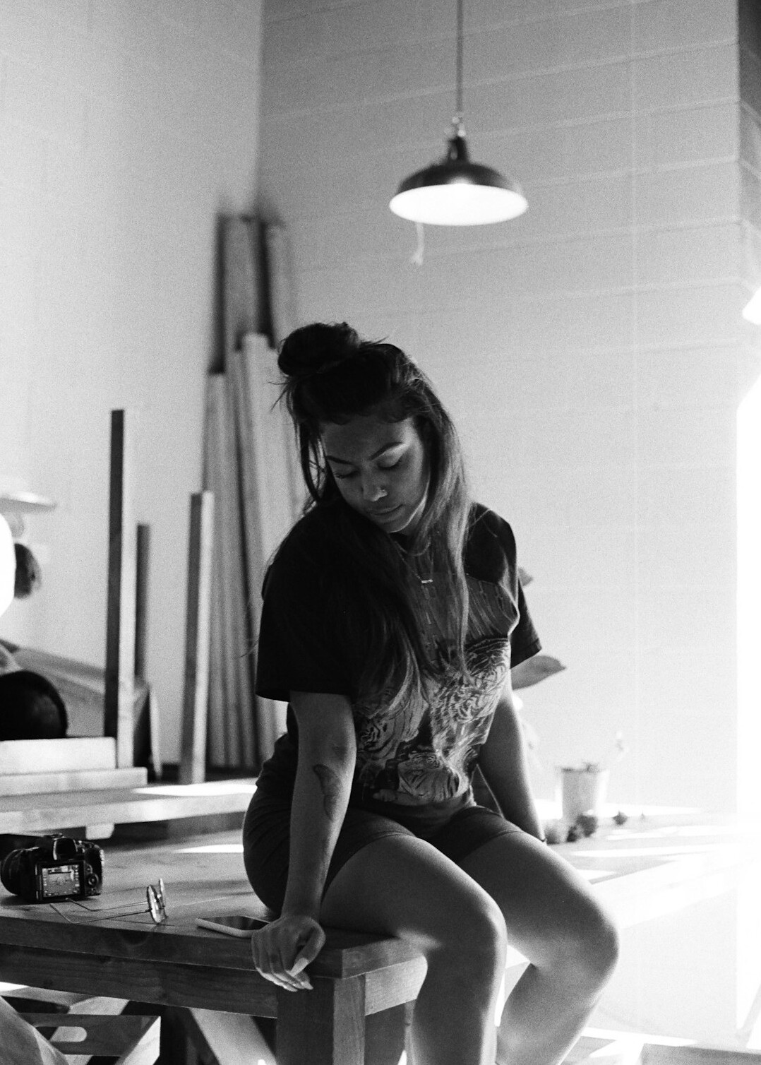 Portrait of a young woman with dark hair smiling in a workshop
